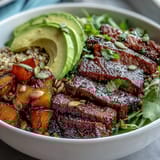 A fork lifts tender beef from this vibrant fusion dinner bowl, drenched in zesty lime-cilantro dressing.