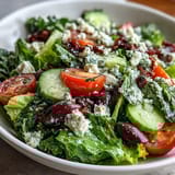 Colorful Mediterranean Green Salad Bowl with Kalamata olives and red onion tossed in a tangy Greek dressing.