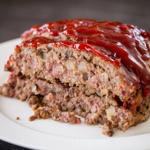 This savory Meatloaf, baked to a delicious crust, is glistening with a homemade ketchup glaze.