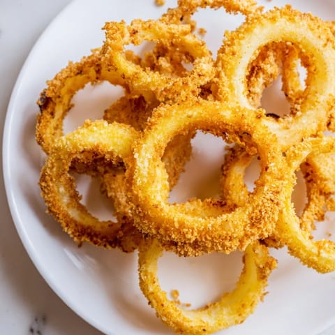 Freshly fried onion rings with a light, airy batter, perfect alongside a spicy dipping sauce.