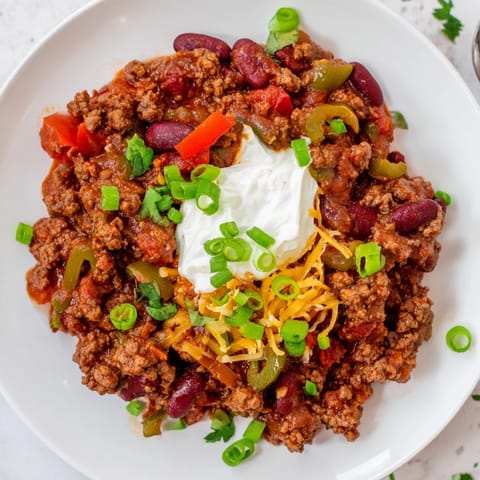 A hearty, flavorful pot of Chili con Carne simmering, perfect for a chilly evening with friends.
