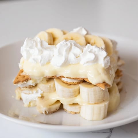 Golden-yellow Banana Pudding filling brimming with ripe banana slices and crisp vanilla wafers in a glass bowl.