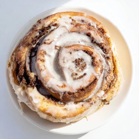 Warm, golden Cinnamon Rolls fresh from the oven, drizzled with sweet, creamy vanilla glaze.