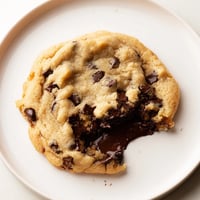 Warm, golden chocolate chip cookies fresh from the oven, ready to enjoy with a glass of milk.
