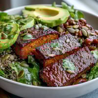 Golden roasted butternut squash steak bowls on fluffy quinoa with creamy avocado, red onion, and pepitas.