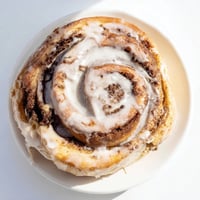 Warm, golden Cinnamon Rolls fresh from the oven, drizzled with sweet, creamy vanilla glaze.